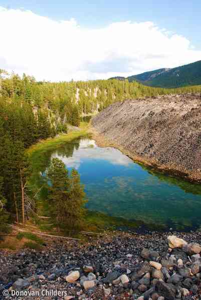 Blue reflections on the small lake by the Big Obsidian Flow at Newberry Volcano